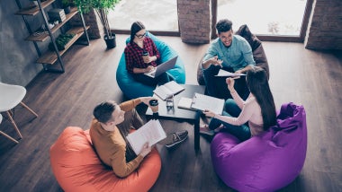 Top above high angle view of nice attractive smart clever interns managers reviewing development attending internship sitting on bag chair at industrial loft interior workplace workstation