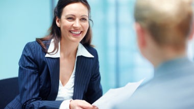 Smiling business woman conversing with executive
