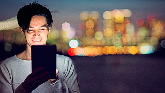 homem com tablet e luzes de cidade desfocadas por trás homem com tablet e luzes de cidade desfocadas por trás