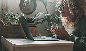 Woman on laptop with coffee