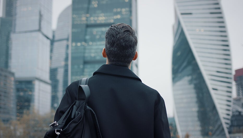 Man looking at high building