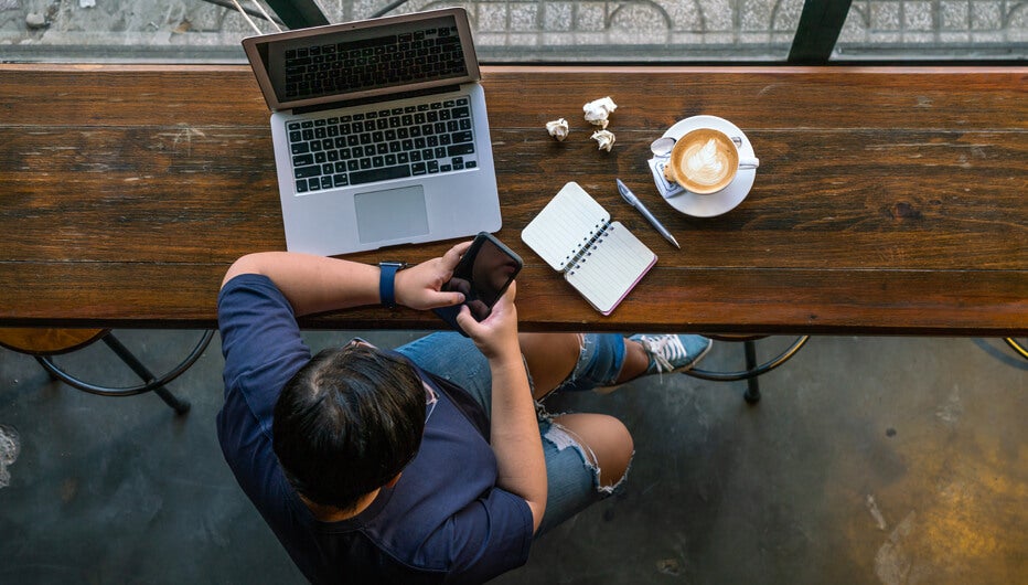 Woman using phone and laptop