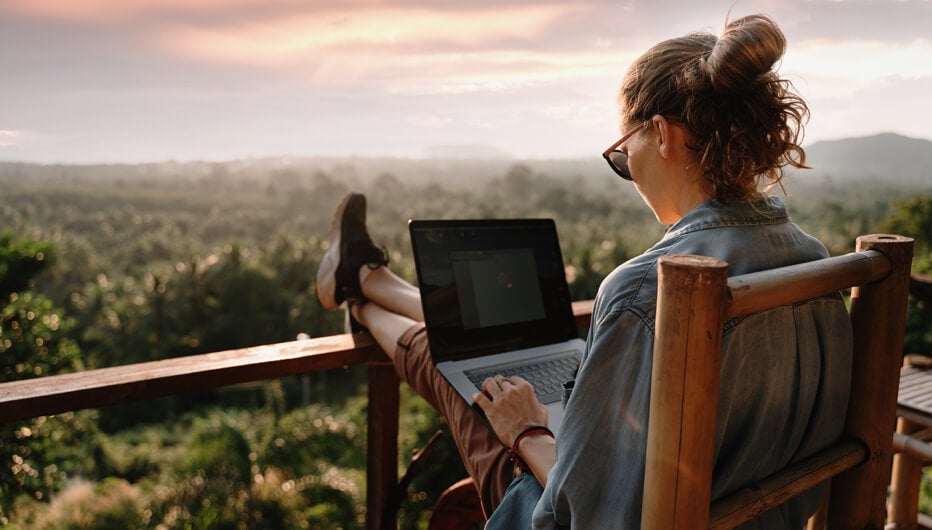 Woman sitting on balcony with laptop