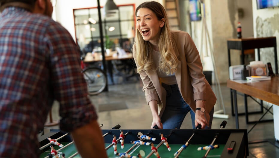 woman playing table football and laughing