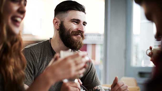 hombre joven con barba en una cafetería